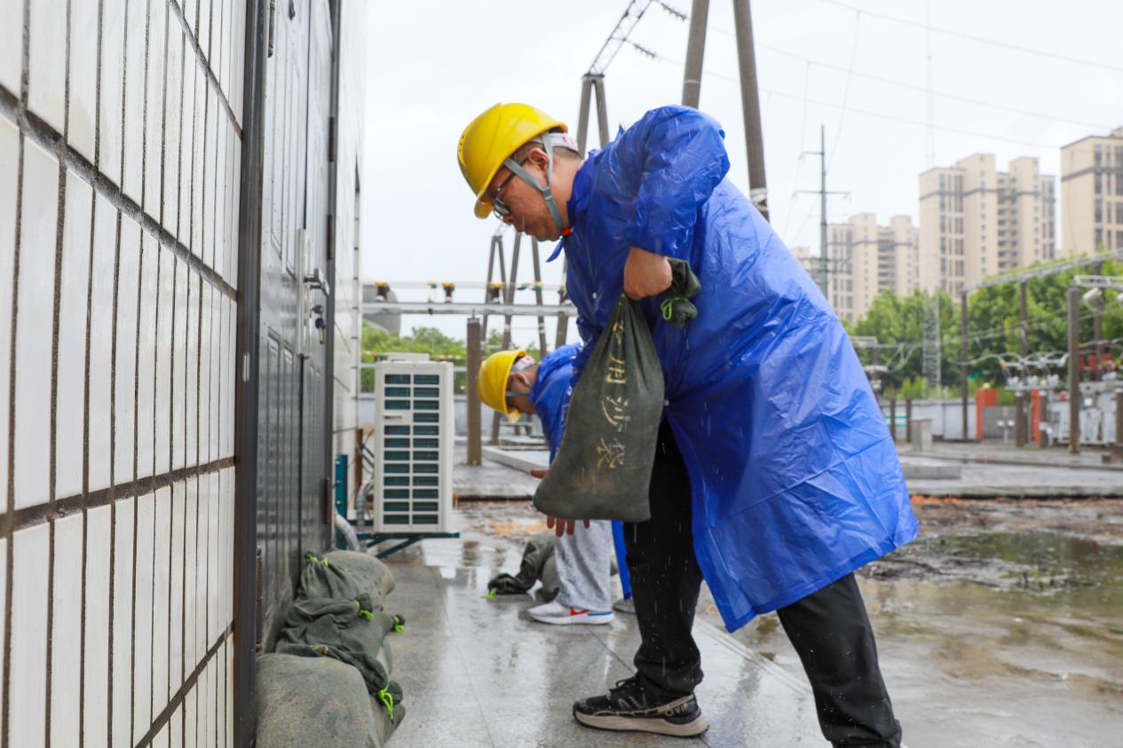 變電運維人員在控制室入口堆放防汛沙袋。