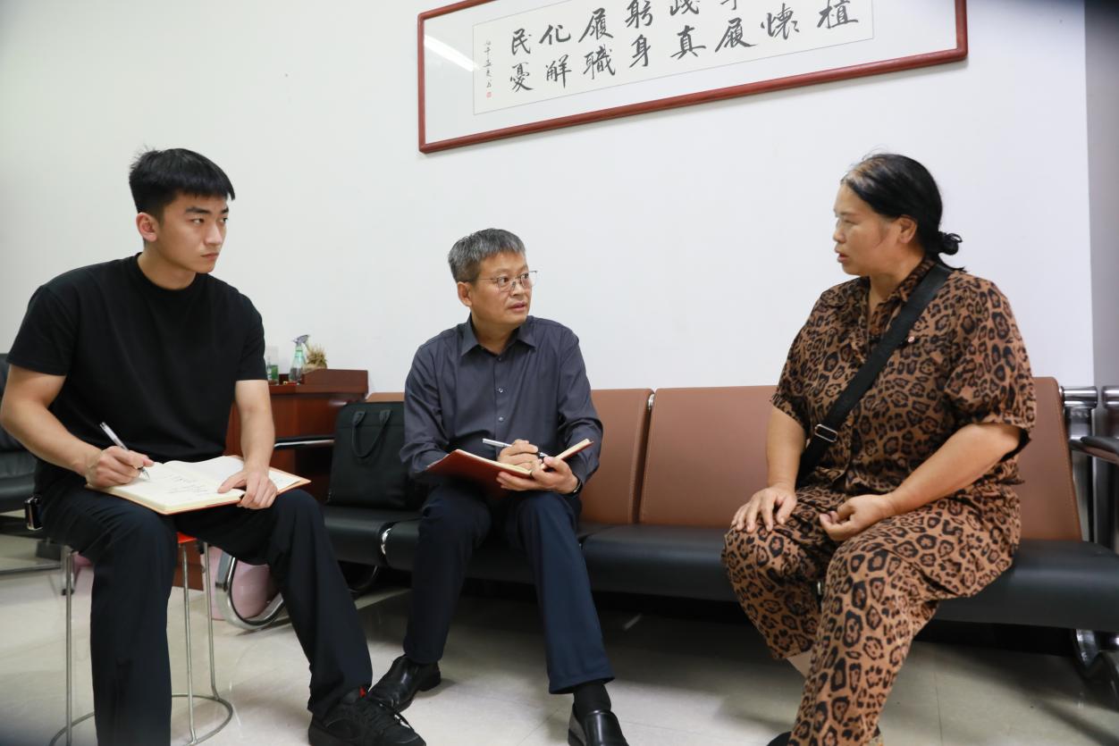 每次接访，刘晓峰（中）都认真倾听，记录群众诉求。杨晓华摄