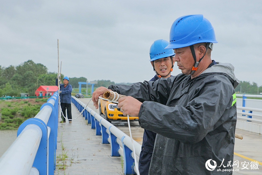 抢险队员正在加固防汛灯具线路。人民网记者 李希蒙摄
