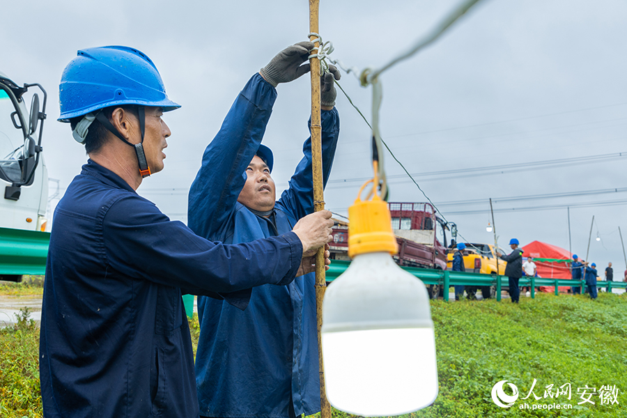 抢险队员正在加固防汛灯具线路。人民网记者 李希蒙摄