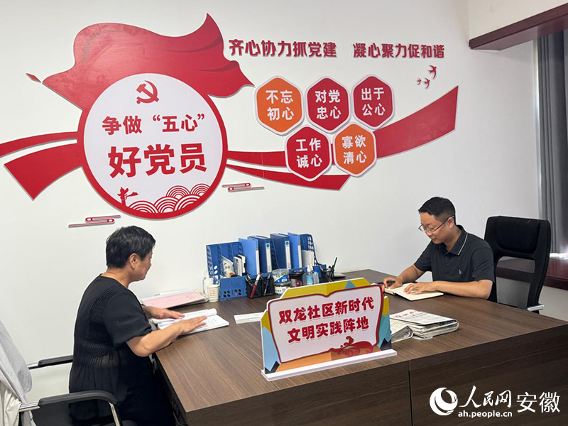 赵明明（右）和同事一起处理辖区工作。人民网记者 吕欢欢摄