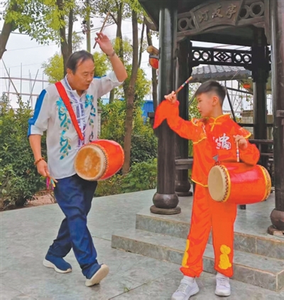 金明（左）在教授花鼓燈舞蹈動作。本報記者 李俊杰攝