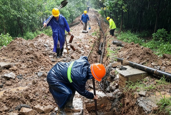 燃氣施工人員冒雨敷設燃氣管道