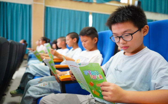 周潭中心学校学生阅读“护苗”宣传册