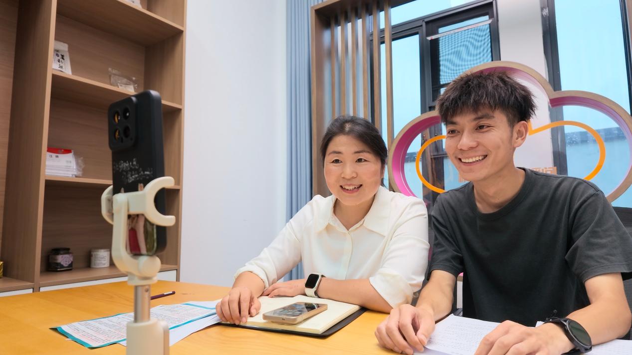 “桥畔梅语”直播间内，梅花村党总支书记杜娟与村干部“小郭老师”介绍村情村貌，与网友互动。余子琪摄