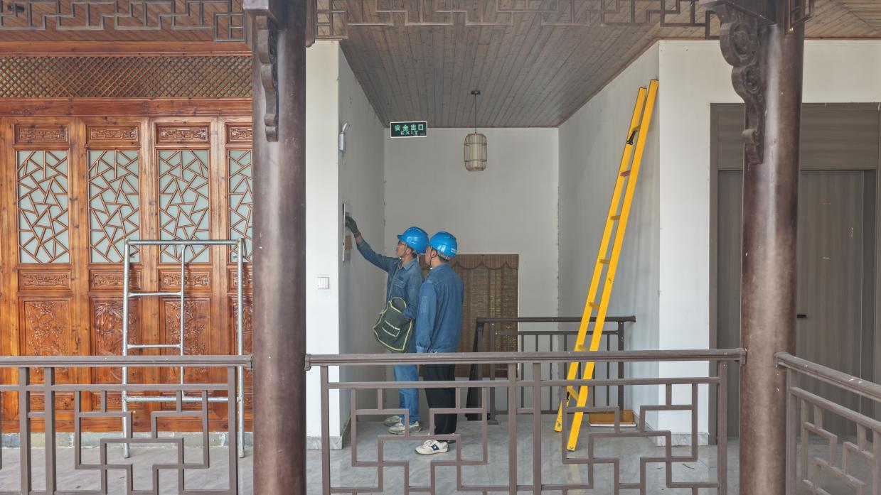 运维人员逐户上门开展用电安全服务。