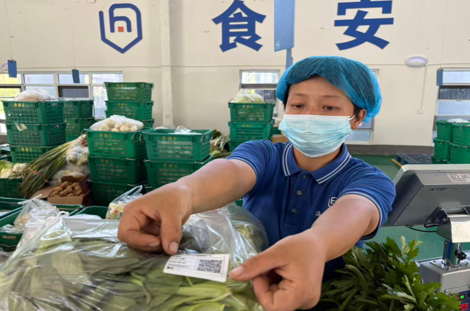 海譙匯工作人員正在給蔬菜貼上二維碼。