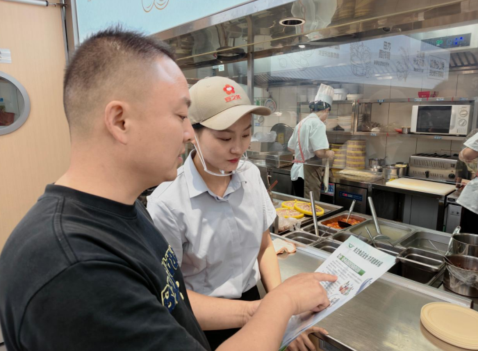 工作人員走訪餐飲店，講解食品安全知識。