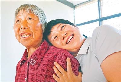 大湾村党总支第一书记余静（右）帮脱贫户张邦若设置智能手机后，放松地靠在她的肩膀上聊起了天。