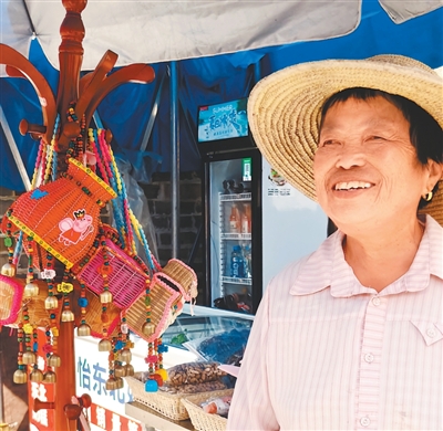 村民袁大荣在家门口售卖农特产品，吸引很多外地游客光顾。
