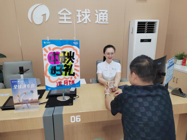 營業廳內，工作人員向辦理業務的用戶贈送月餅