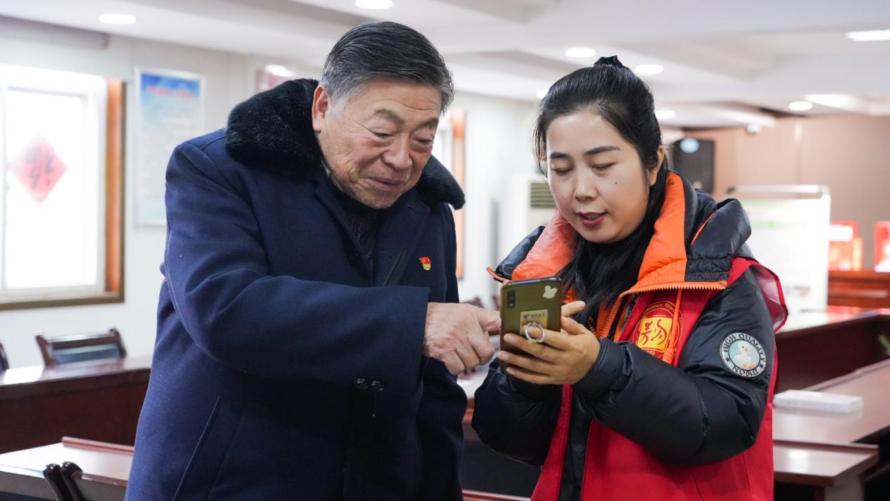 泗州路社區志願者教老黨員用手機參與公益。合肥市民政局供圖