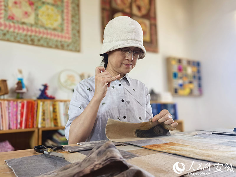 工作台前，章慧手工缝纫。人民网记者 汪瑞华摄