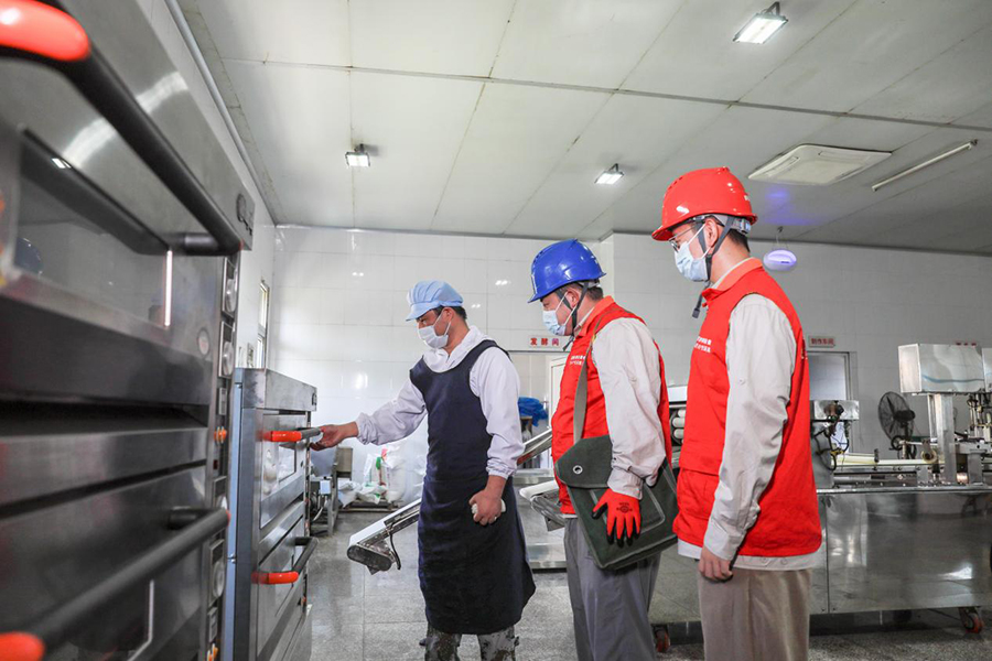 国网肥东县供电公司员工查看合肥公和堂食品有限公司工厂生产设备安全运行情况。陈海东摄