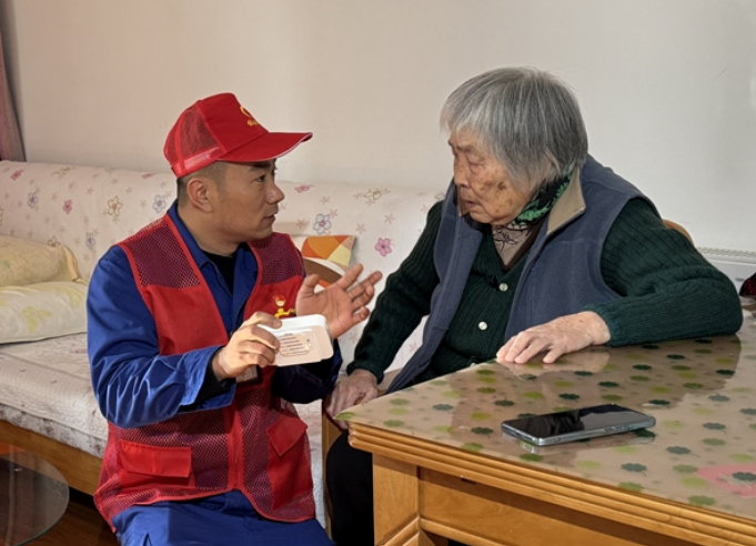 “銀齡安居”項目牽頭人宗洪博為老人介紹燃氣報警器。合燃華潤燃氣供圖