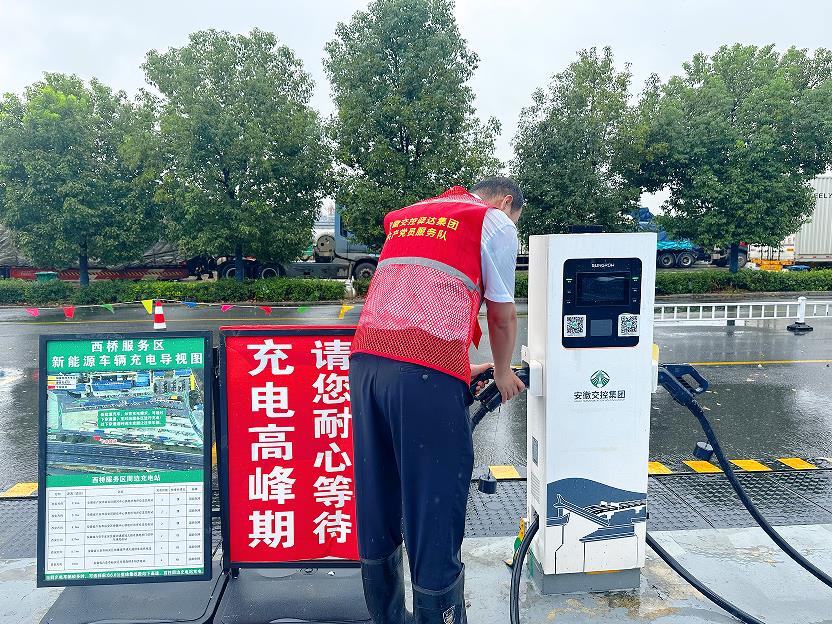 西桥服务区工作人员检查充电桩接口。