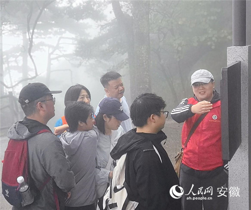 徐奇（右一）正在為游客耐心講解游山路線。人民網記者 汪瑞華攝