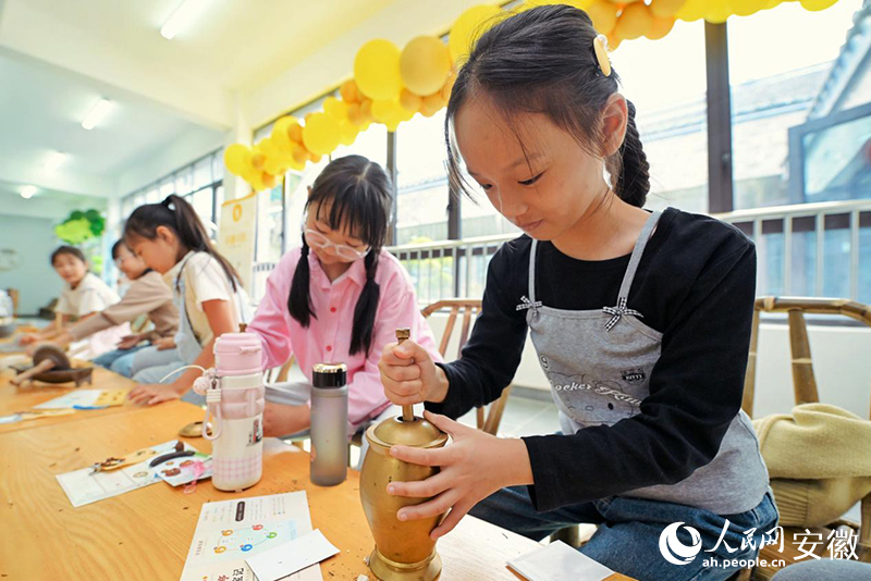 孩子们在体验区感受中药制作过程。人民网记者 周坤摄