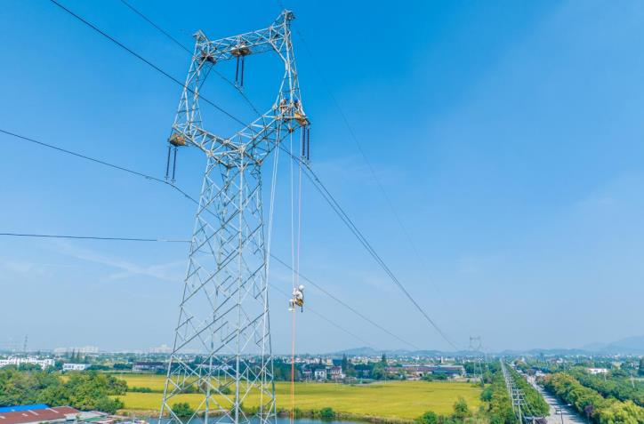 電網員工通過載人升降設備抵達高空作業點。陶洋攝