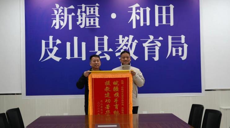 皮山县教育局向灵璧援疆教师蒋武（右）赠送感谢锦旗。汪久松摄