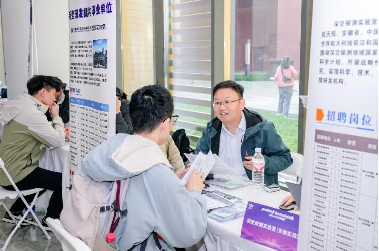 西安電子科技大學招聘會現場，招聘專員與求職大學生交流。