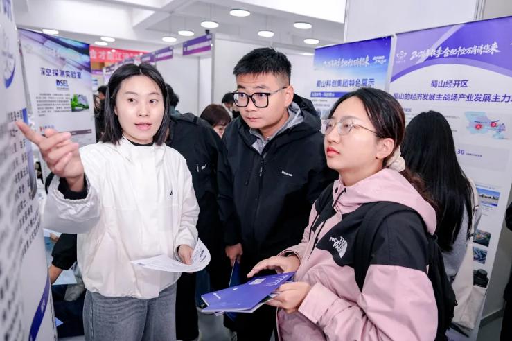 西安交通大學招聘會現場，工作人員向求職者介紹崗位信息。