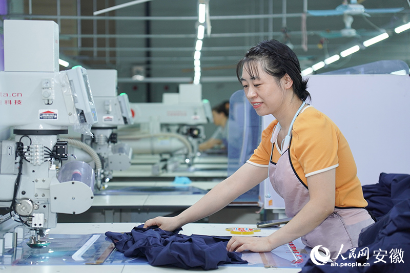 位于枞阳的安徽德昇服饰有限公司厂房内，工人正在工作。人民网记者 陈若天摄
