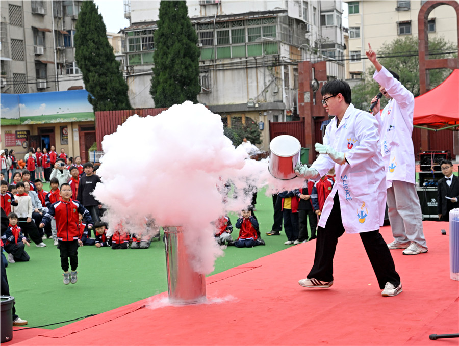 小学生观看科学游戏表演。