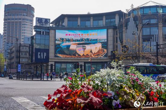 3月29日，杭州湖滨街区户外屏幕上，数十幅亚运宣传海报循环播放。人民网 章勇涛摄