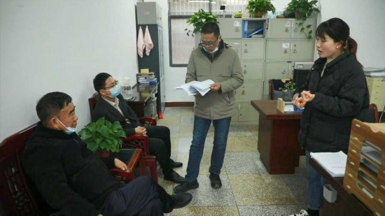 徐淙祥（左）正在太和县民政局办理相关协会成立手续。陶涛 摄