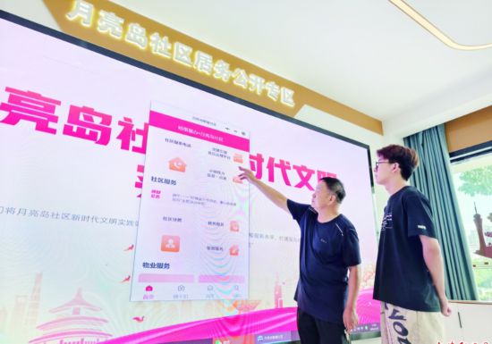 裕安區月亮島社區網格員向居民介紹“裕事慧辦”平台的使用和功能情況。王睿 攝