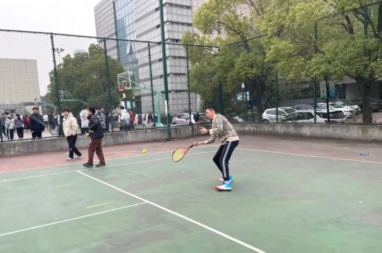 在合肥市五十中天鹅湖校教育集团天鹅湖校区的操场上，同学们在打网球。