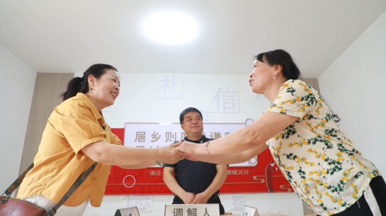 圖為“六尺巷工作法”讓矛盾雙方握手言和。