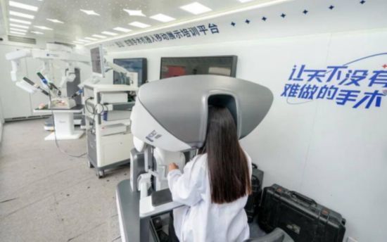 在安醫大站內，培訓師正在操作微創機器人。