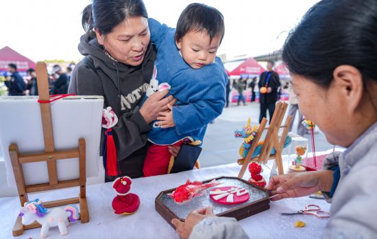 法治文化元素巧妙融入非遺作品,吸引市民紛紛關注。