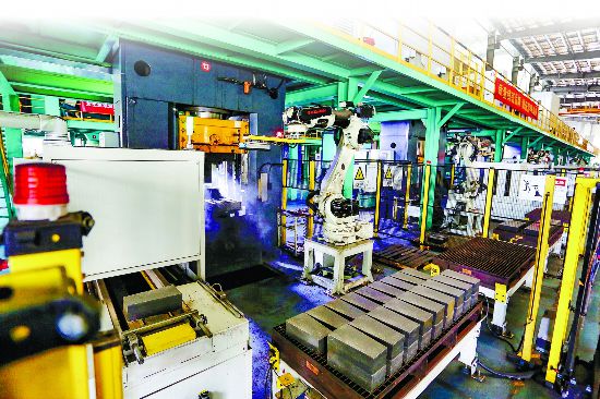 在瑞泰马钢RH精炼炉用节能环保型新材料数字化车间里，机械臂正精准地抓取、码放一块块深灰色的砖坯。通讯员 毕琛 摄