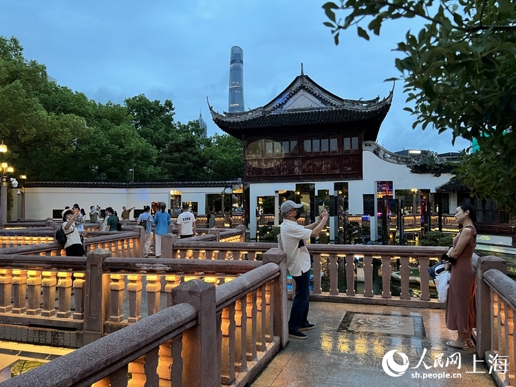 夜幕降临，游客打卡上海豫园九曲桥。人民网 王文娟摄