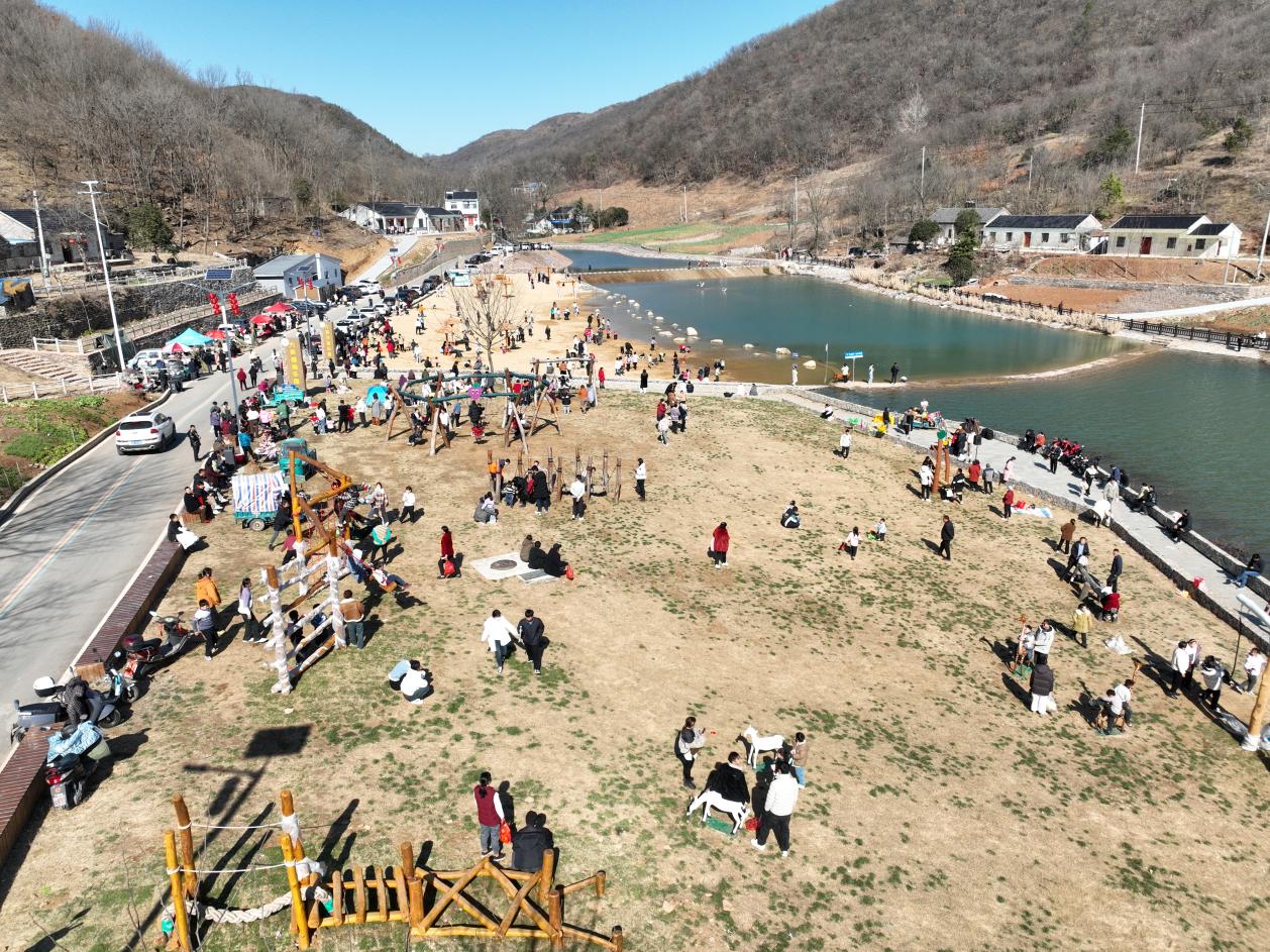 游客在六衖石头部落戏水沙滩边游玩。含山网供图