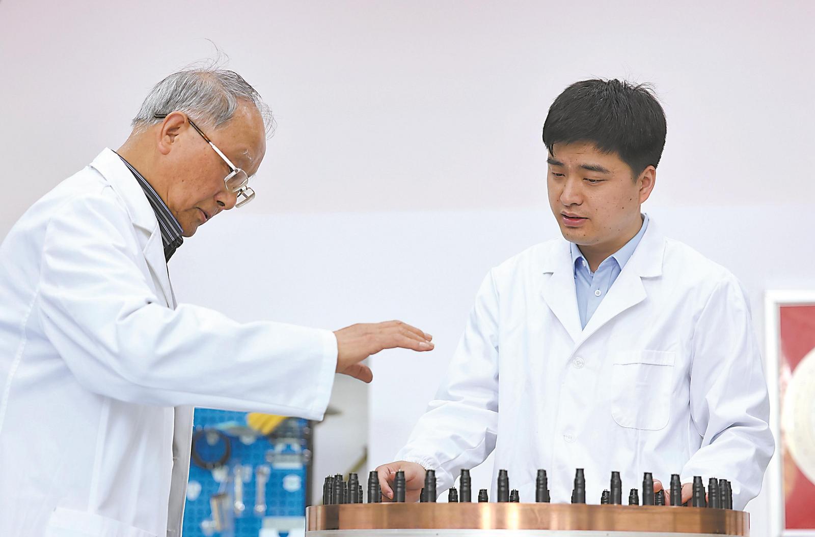 4月22日，在中國科學院合肥物質科學研究院強磁場科學中心，房震（右）與首席專家高秉鈞討論水冷磁體的研發改進問題。